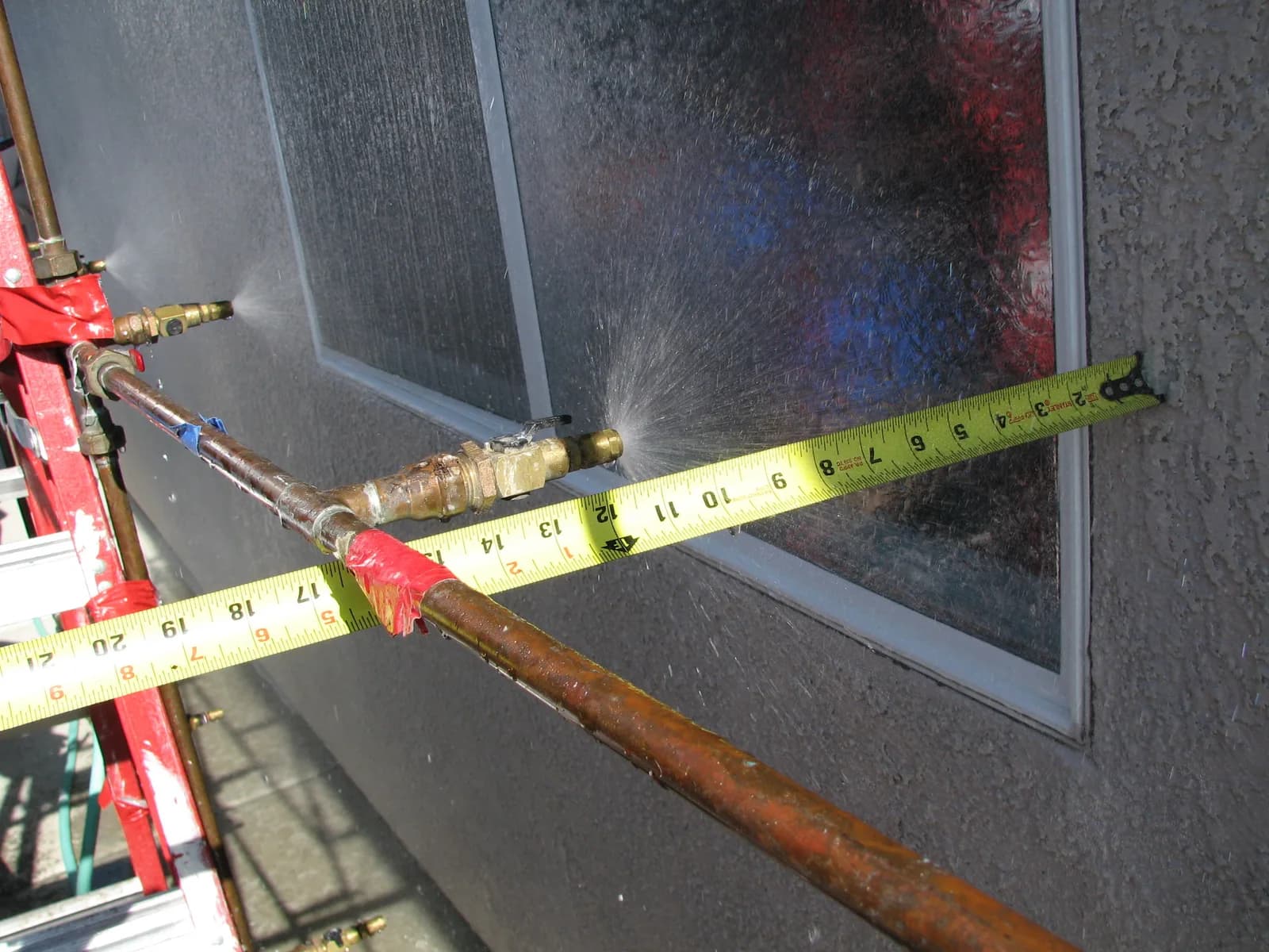 Calibrated water spray test in progress on a building window assembly
